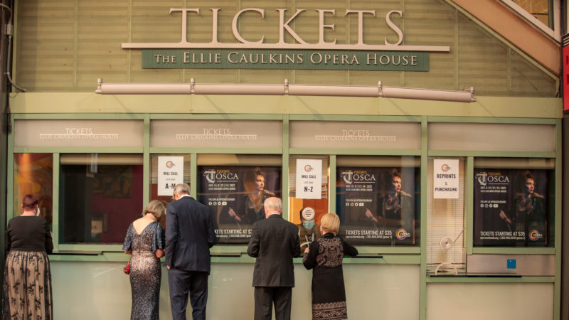 Opera patrons in gowns and suits get their tickets at the Ellie box office.