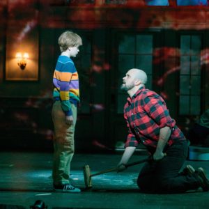 Edward Parks as Jack Torrance kneels before his son Danny, played by Michah Vonfeldt