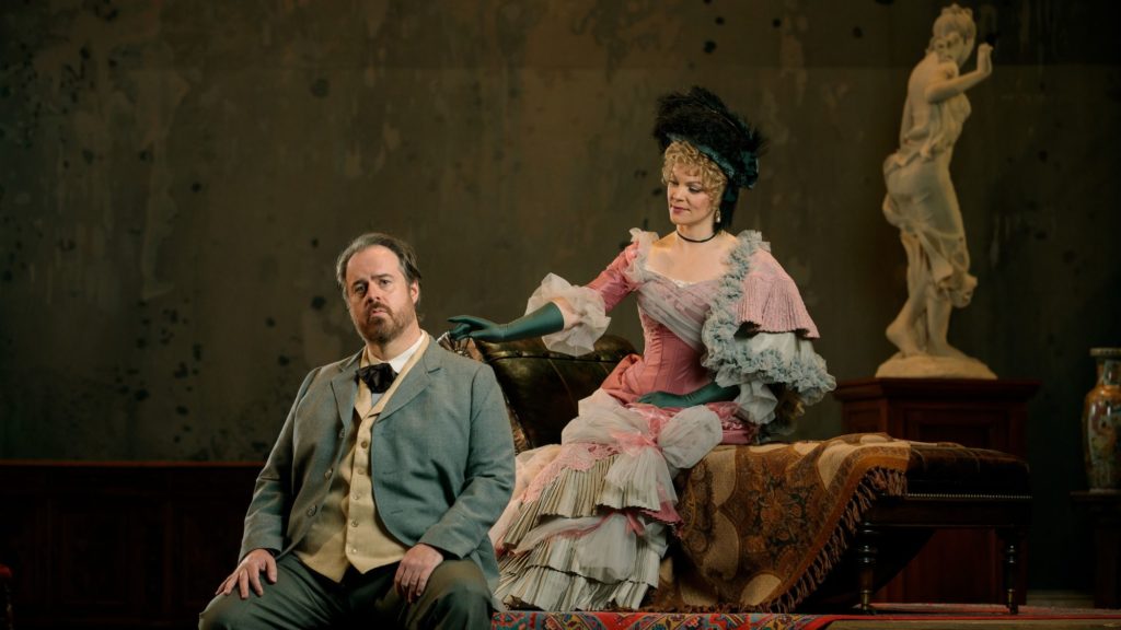 Woman in a pink dress reaches her hand to towards a man