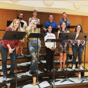 Chorus members stand on risers during the recording.