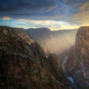 Sunlight begins to illuminate the immense dark of Black Canyon of the Gunnison