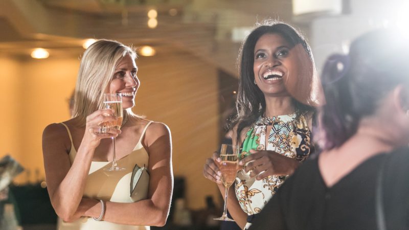Opera patrons smile while drinking bubbly