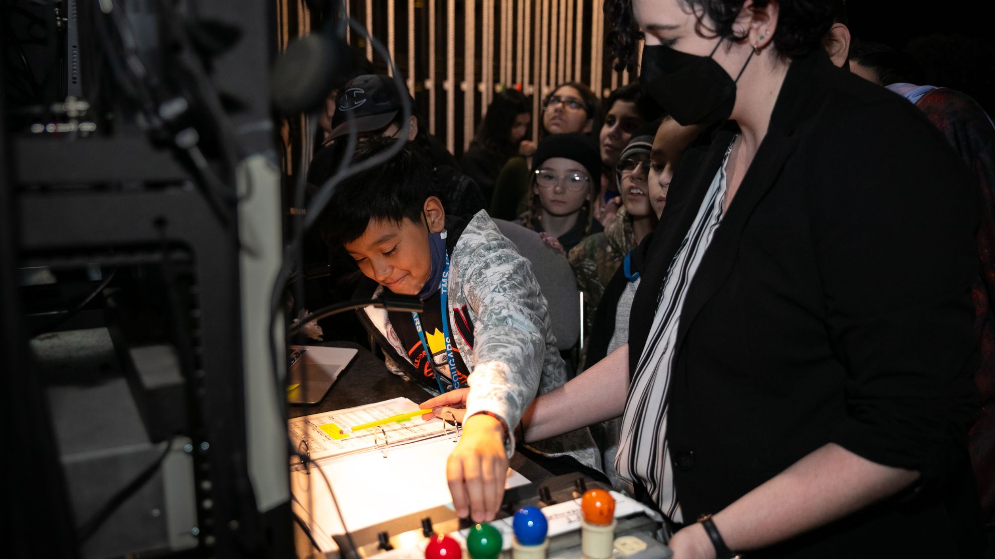 A young boy learns which buttons to push on a switchboard