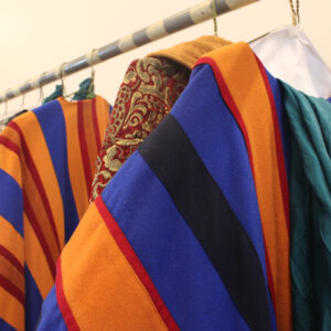 Robes with blue, orange, red, navy, and teal stripes hang on a rack