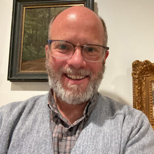 Headshot of a man facing the camera in a gray sweater