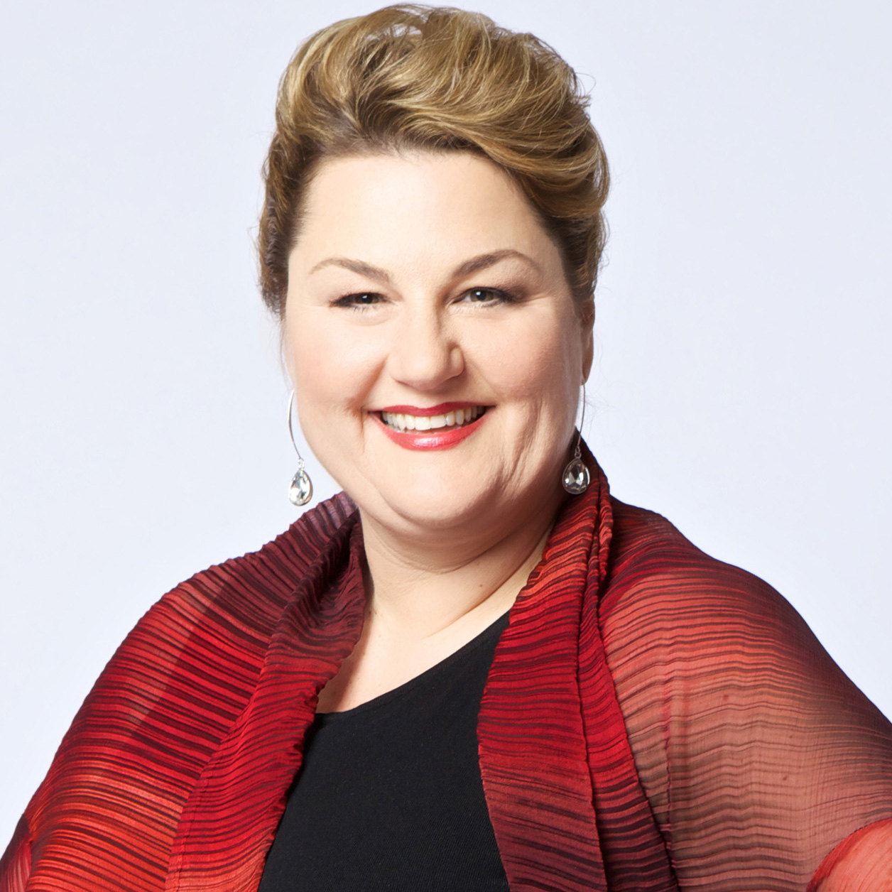 Headshot of a woman with blone hair and a red shawl