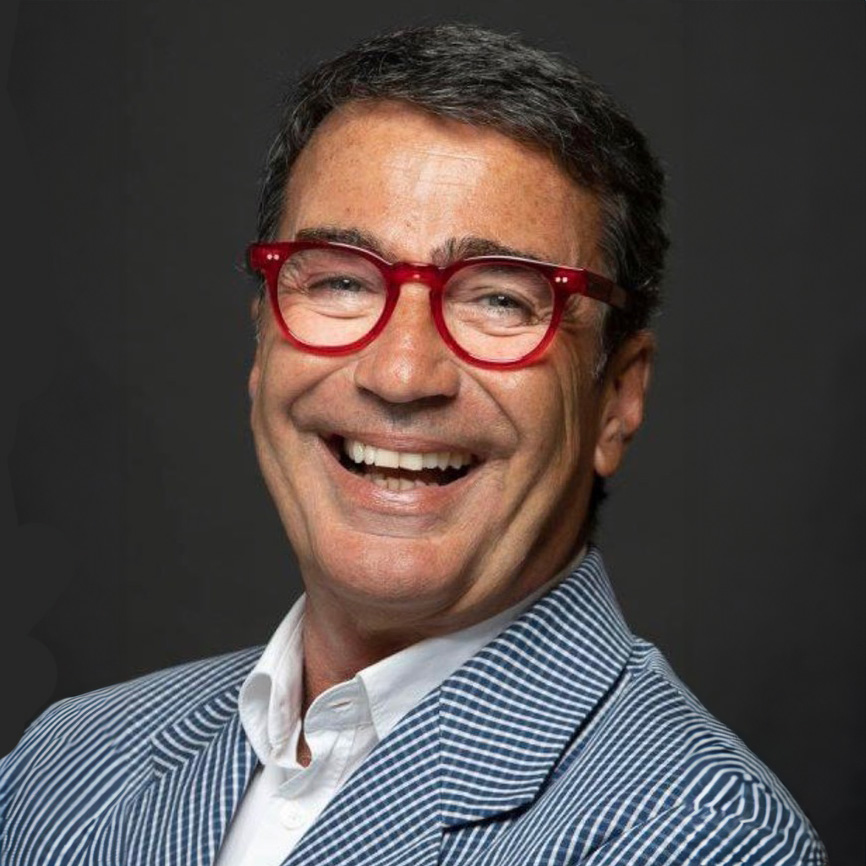 Headshot of a man with dark hair and red glasses