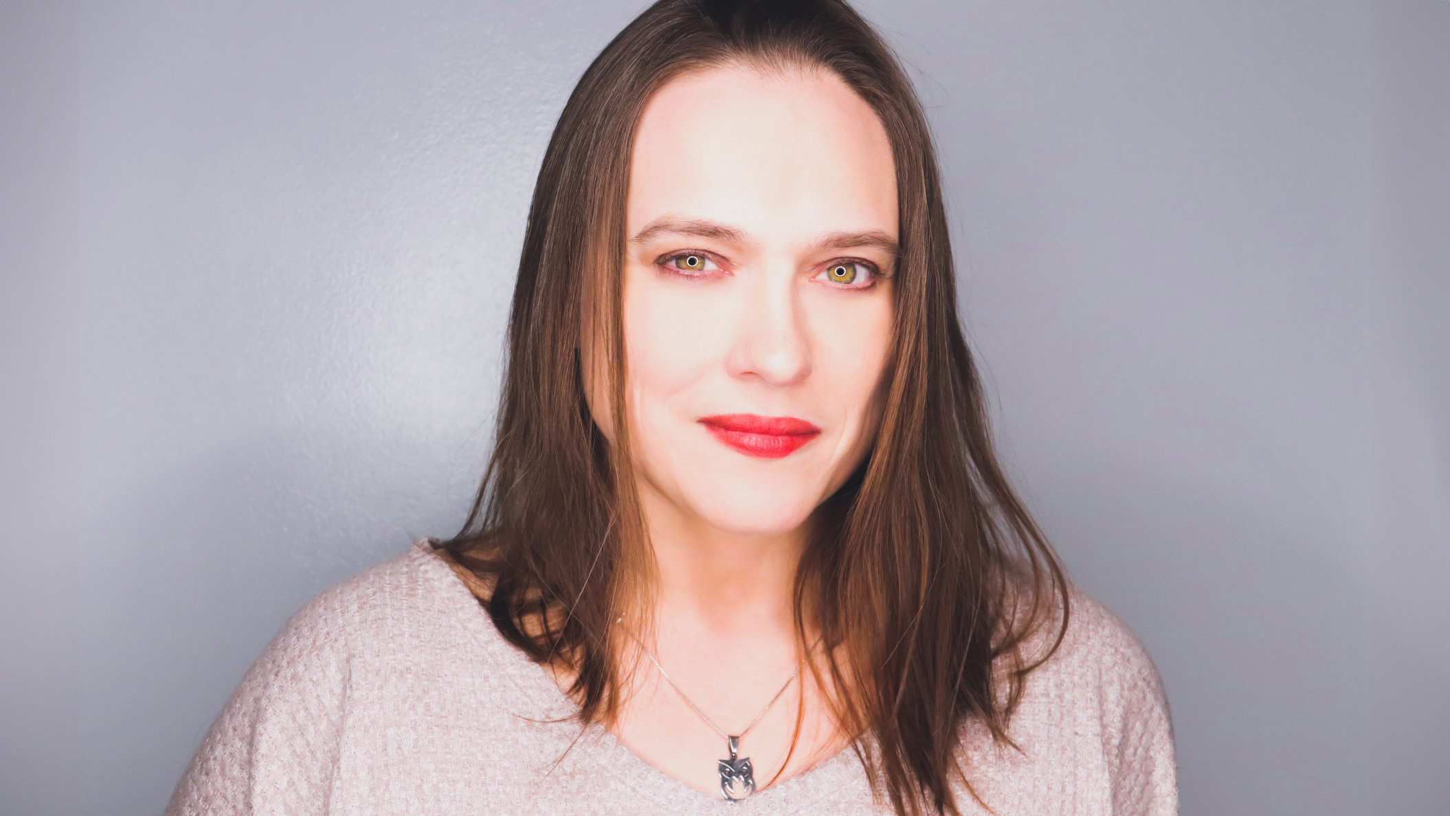 Headshot of a woman with shoulder-length brown hair and green eyes