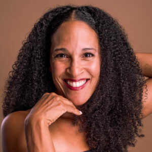 Headshot of a woman with dark curly hair